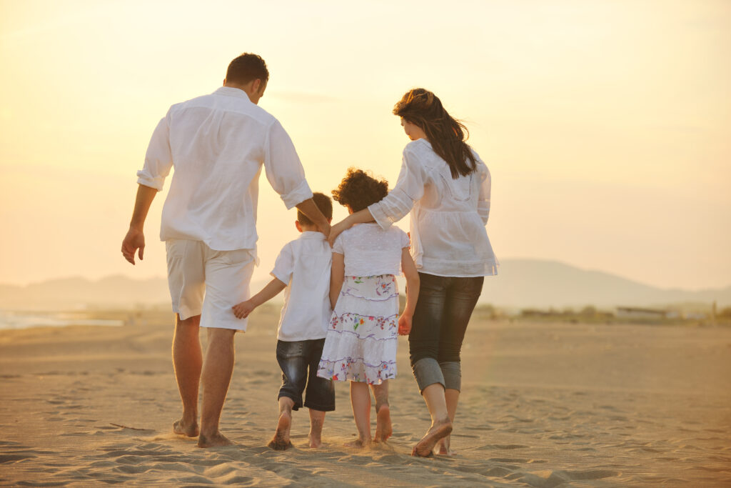 happy young family have fun on beach at sunset